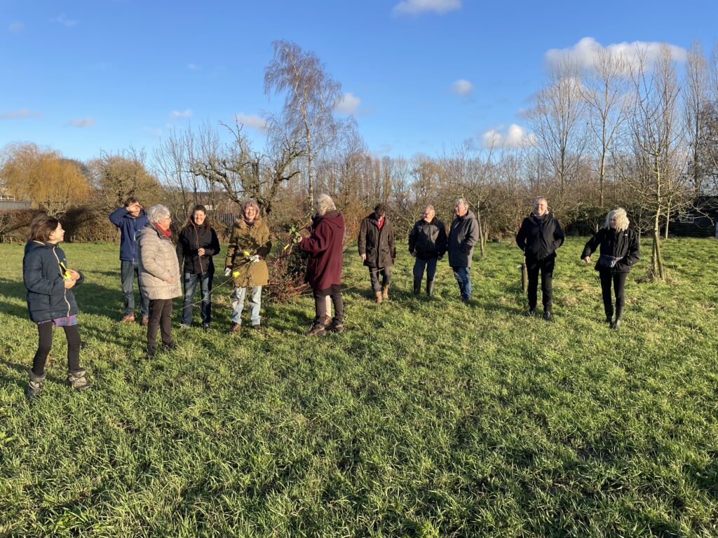 Twee foto's van een groep mensen. Eerst aan de koffie en later in het veld waar ze uitleg krijgen.